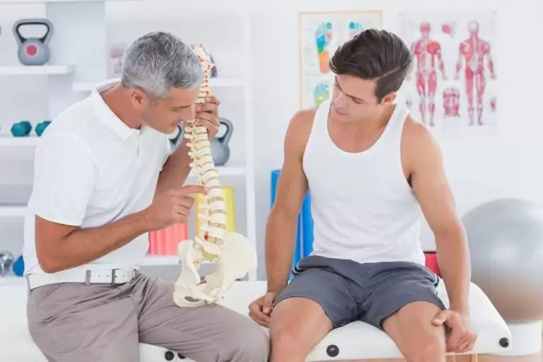 A chiropractor checking a patient’s back