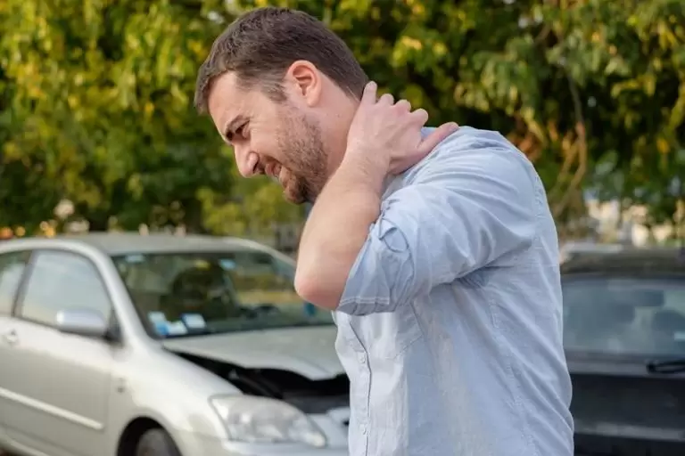 A driver holding her neck after a car accident