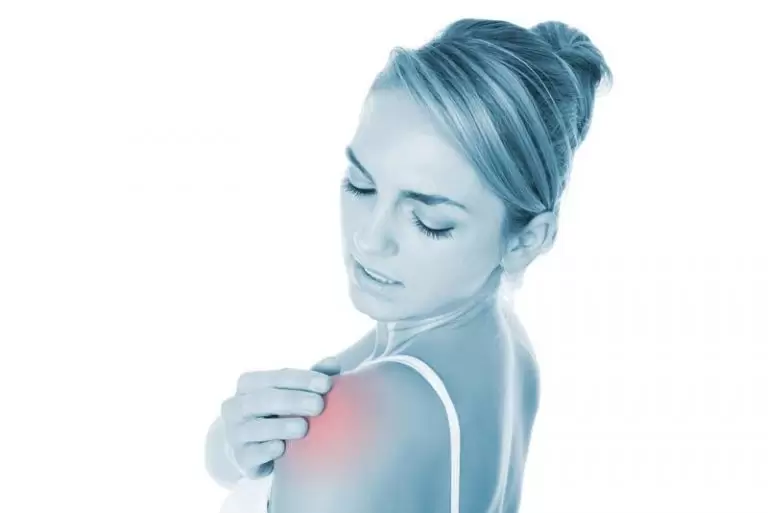 A woman holding her sore shoulder