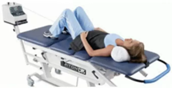A patient lying on the spinal decompression table